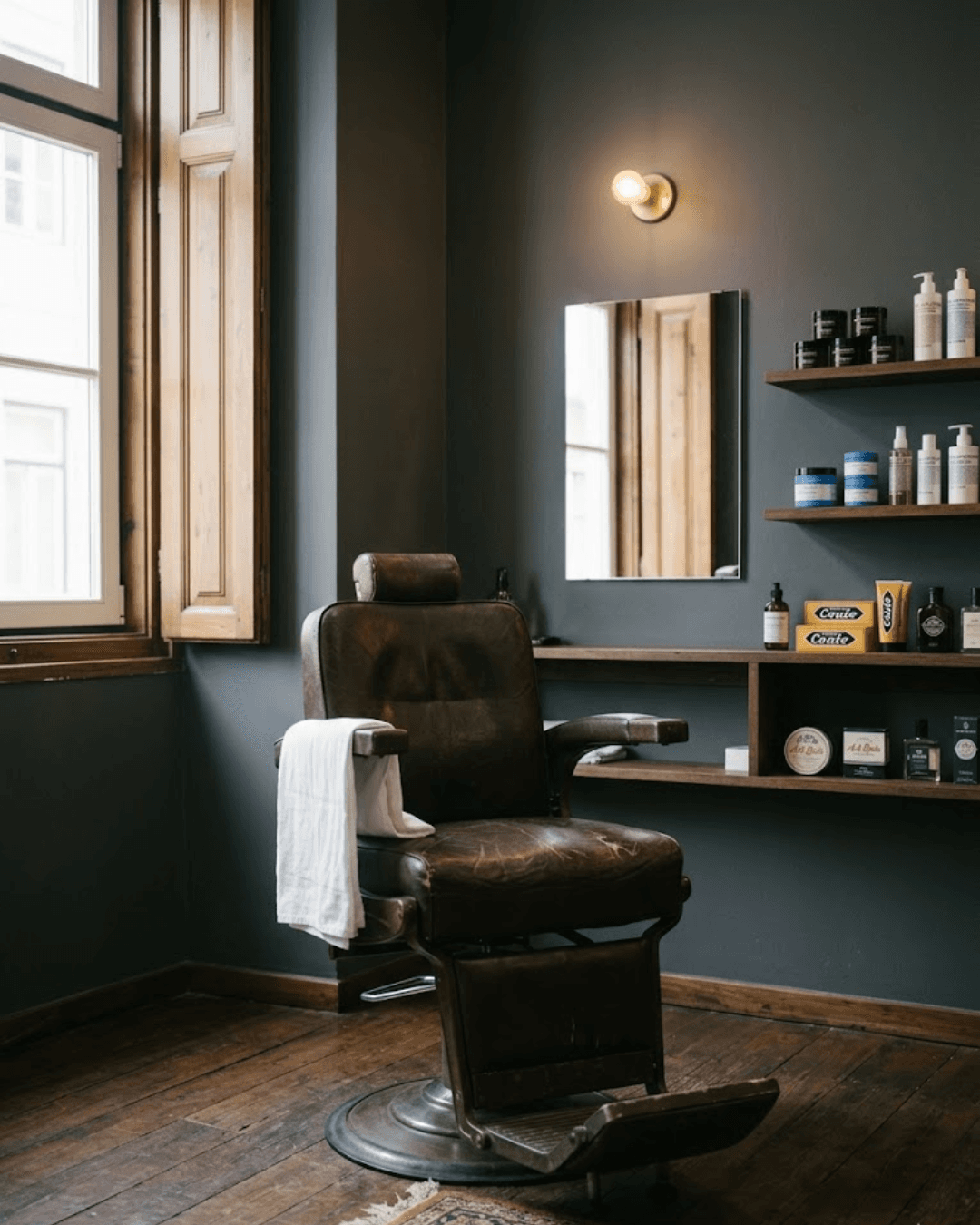 Interior do atelier — cadeira de couro, prateleiras de produtos e luz natural na Rua Augusta